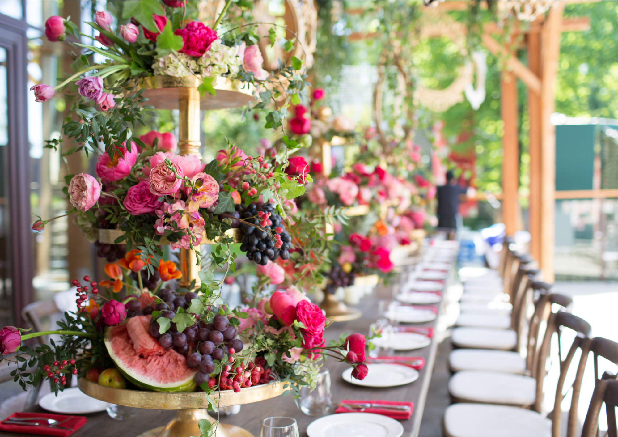 Hochzeitstisch deckt mit pinken Servietten, bunten verschiedenen Blumen in den Farben Pink Rosa Weiß Grün