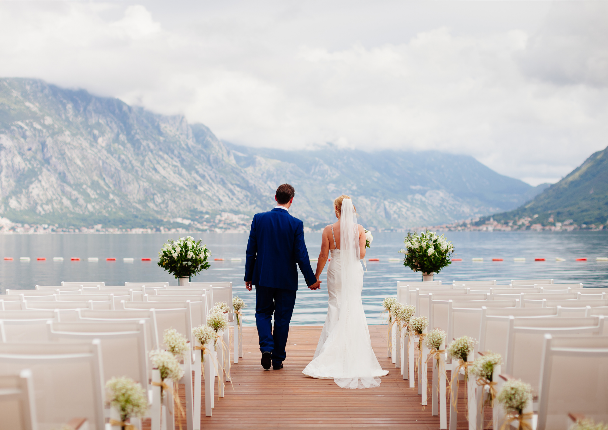 Brautpaar auf dem Steg am See auf dem Weg zu ihrer Trauung